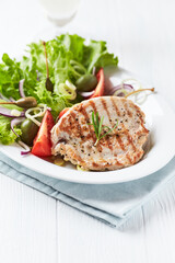 Grilled Turkey Breast with fresh salad. Bright background.