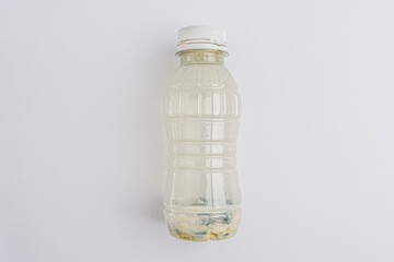 dirty plastic yogurt bottle on a white background, isolated