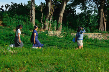 Fototapeta premium As they move along a narrow footpath, the girls take their time scanning the area, staying alert and observing their environment in search of a suitable camping spot.