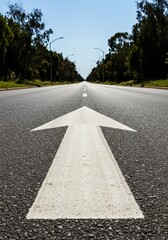 Perspective Photo of White Arrow on Asphalt Road Under Blue Sky