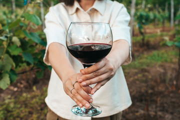 Woman Holding Glass of Red Wine in Vineyard Setting