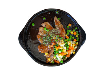 Grilled pork chop with vegetables on black plate isolated on white background