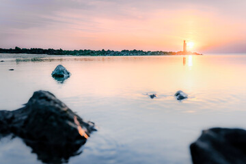 Serene Sunrise at the Coast with Distant Lightsignal