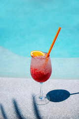 A delicious berry cocktail in an elegant glass on the side of the pool. A cup of cool summer drink...