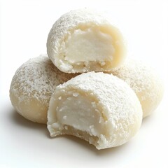 Delicious white coconut candies with a creamy filling and powdered sugar coating stacked together on a white background for dessert or snack