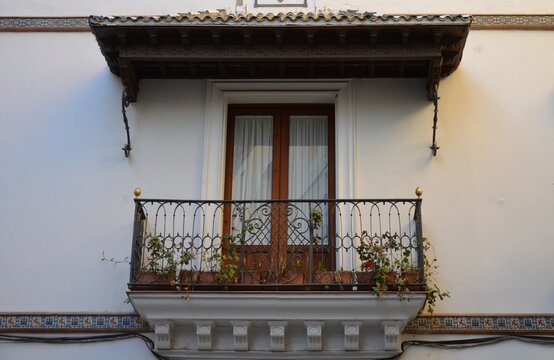 The exterior of a historical residential building with balconies in Seville, Andalusia, Spain