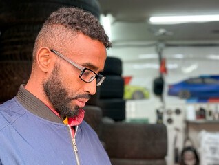 Adult african american ethnicity man with a beard and glasses. A black guy a blue jacket posing....