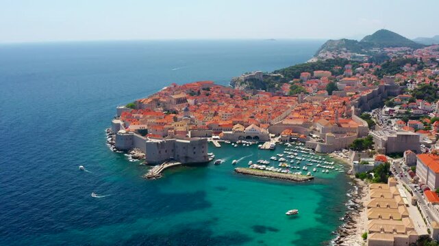 Establishing aerial shot of Dubrovnik, Croatia. Iconic old town, medieval walls, and breathtaking coastline. Beauty of the Adriatic Sea and landmark historic architecture. 4K drone wide orbit footage