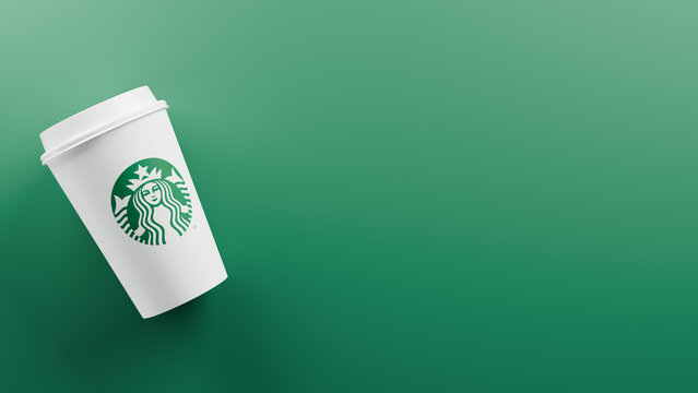 A White Starbucks Takeout Cup Lying on a Green Background