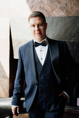 portrait of groom in blue tuxedo in hotel