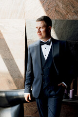 portrait of groom in blue tuxedo in hotel