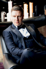 portrait of groom in blue tuxedo in hotel