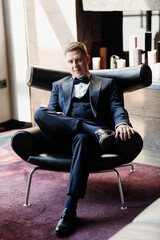 portrait of groom in blue tuxedo in hotel