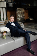 portrait of groom in blue tuxedo in hotel