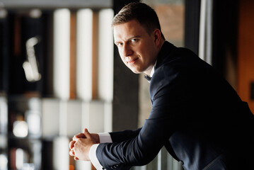 portrait of groom in blue tuxedo in hotel