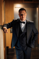 portrait of groom in blue tuxedo in hotel