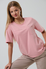 Fototapeta premium Girl model in casual clothes on a gray background posing in the studio