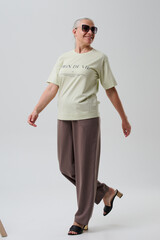 Woman in casual clothes posing in studio on grey background.