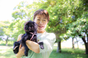ペットの犬を抱く日本人の女性