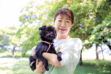 ペットの犬を抱く日本人の女性