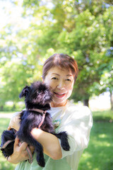 ペットの犬を抱く日本人の女性