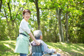 日本人の女性ヘルパー　公園を車椅子の老人と散歩