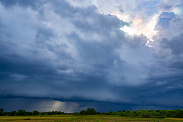 Obraz premium storm clouds over green field