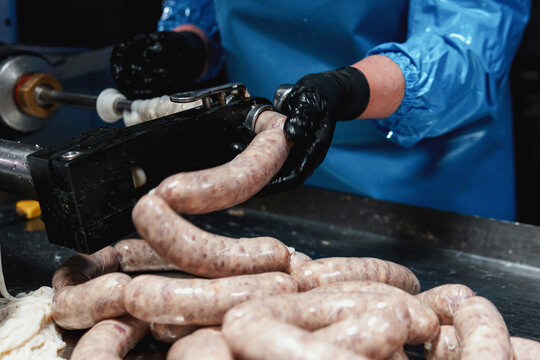 Close up of sausages production process at the meat factory.