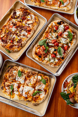 Delightful flatbreads topped with fresh ingredients, served in a charming eatery. Perfect for gathering with friends to enjoy a leisurely meal under warm sunlight