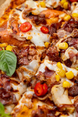A vibrant ensemble of fresh ingredients covers a warm, crispy pizza, showcasing a blend of savory meats, sweet corn, and colorful peppers, inviting a delightful culinary adventure