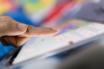 Fingers poking the tablet screen macro,Extreme close up of female finger using digital tablet...
