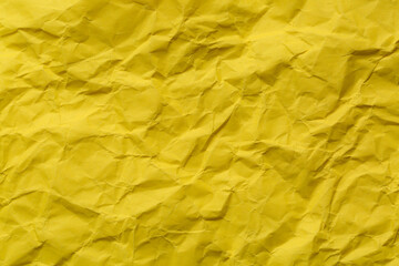 Close-up of yellow crumpled paper background,Macro yellow crumpled paper texture,Macro close up of yellow crumpled paper texture, Crumpled sheet of yellow paper close up. 