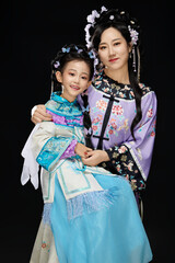 Portrait of Chinese mother and daughter dressed in Hanfu costumes on black background