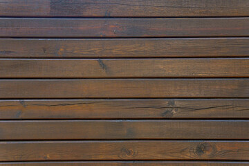 Dark brown old wooden planks arranged in horizontal rows. Abstract vintage background.