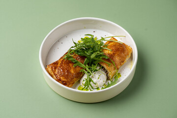 Golden-brown, crispy rolls sit atop a bed of creamy sauce, garnished with vibrant green herbs. This culinary delight embodies both sophistication and flavor, ideal for a gourmet meal