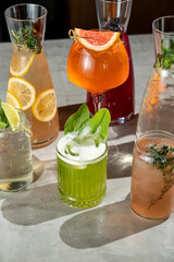 Vibrant cocktails featuring fresh fruits and herbs sit elegantly on a table, inviting patrons to...