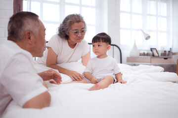 Fototapeta premium Before putting the kids to bed, grandparents, and kid unwind and play in the bedroom