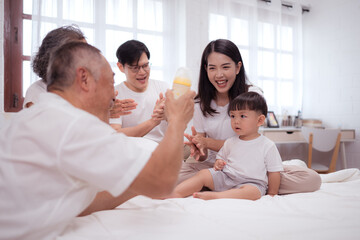 Fototapeta premium Before putting the kids to bed, parents, grandparents, and kid unwind and play in the bedroom