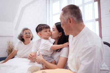 Fototapeta premium Before putting the kids to bed, parents, grandparents, and kid unwind and play in the bedroom