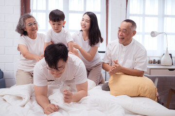 Fototapeta premium Before putting the kids to bed, parents, grandparents, and kid unwind and play in the bedroom