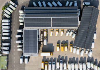 Delivery vans and trucks hub with solar panels on a roof. Fleet of vehicles.