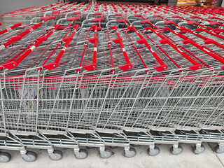 A row of shopping carts is neatly lined up in a straight row