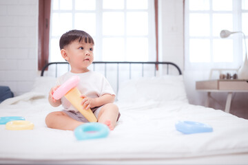 Fototapeta premium Before putting the kids to bed, kid unwind and play with toy in the bedroom