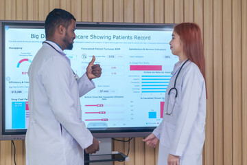 multiracial medical doctors team discuss together during seminar with growth chart on screen monitor in meeting room