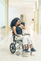 portrait african woman afro client sitting on wheelchair at corridor,getting service at hospital