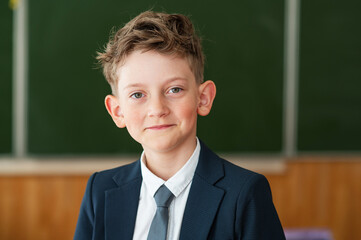 Portrait of a schoolboy, first grader standing in the classroom and looking at the camera. Education. The new generation. Back to school concept