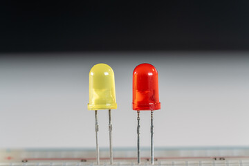 Yellow and red LED parts in scientific experimental setup as macro shot on white and black...