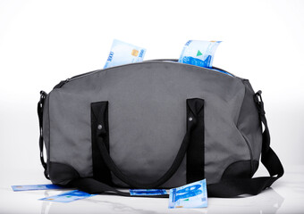 Gray bag full of Nigerian naira notes currency money with some of the money fallen on table desk surface over white background 