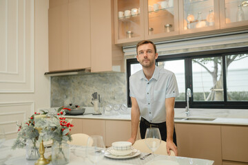 Man in modern kitchen is sleek and contemporary, featuring beige cabinets and a large window allowing natural light to fill the space is home decoration life style. 