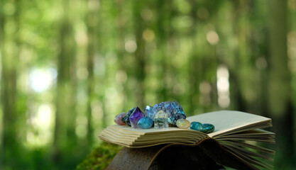 witch spell book and set of quartz minerals in forest, abstract natural background. Gemstones for Magic Crystal Ritual. Witchcraft, spiritual esoteric practice. stone therapy. mystery atmosphere